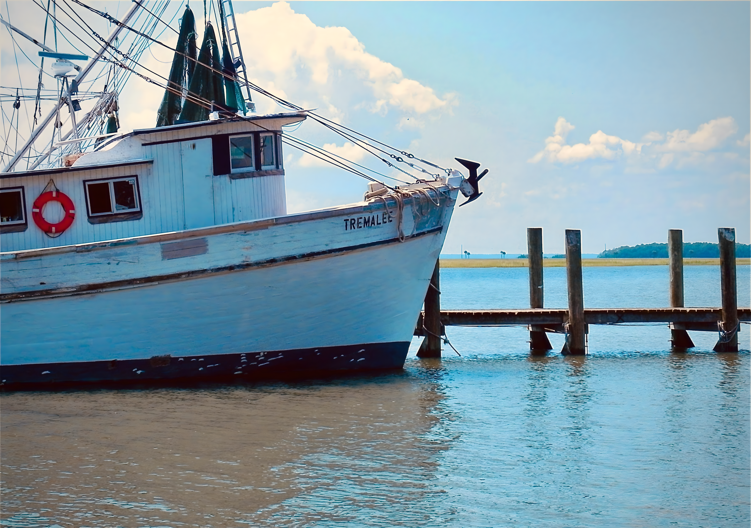Bow of a weathered Lowcountry shrimp boat at the dock at dawn.